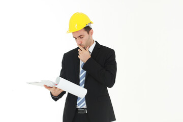 Handsome and smart engineer in black suit Wearing a yellow safety engineer hat with hand holding Construction drawing papers and serious in work isolated on yellow background. Copy Space