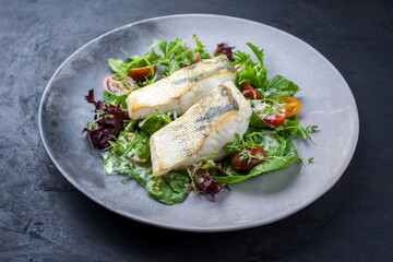 Traditionelles gebratenes Skrei Kabeljau Fish Filet mit italienischen Salat und Tomatenin Zitronen...