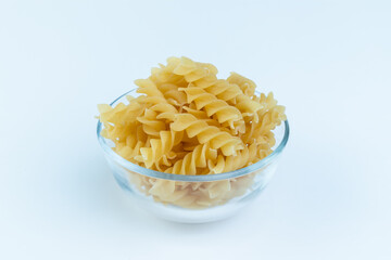 Raw pasta in a cup is isolated.