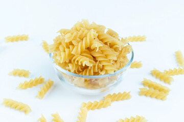 Raw pasta in a cup is isolated.