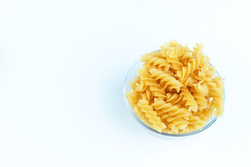 Raw pasta in a cup is isolated.