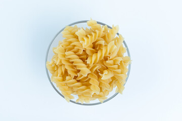 Raw pasta in a cup is isolated.