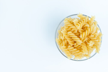 Raw pasta in a cup is isolated.
