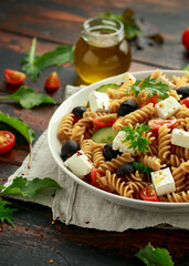 Pasta salad with tomato, black olives, cucumber and feta cheese. healthy food.