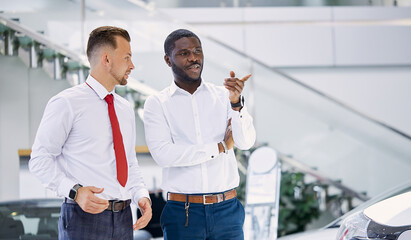 african client man ask questions about car he is interested on, responsive sales agent help him and consult