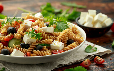 Pasta salad with tomato, black olives, cucumber and feta cheese. healthy food.
