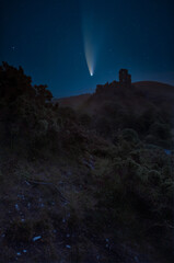 Fototapeta na wymiar Digital composite image of Neowise Comet over Romantic fantasy magical castle ruins against stunning vibrant sunrise