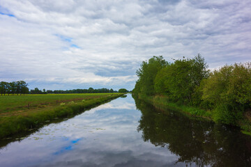 Fototapeta na wymiar Landscape with clouds reflecting in the channel near Almelo, Netherlands 