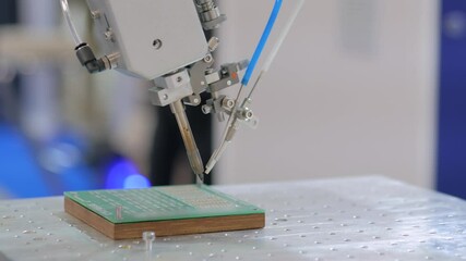 Process of selective soldering components to printed circuit board in demonstration mode at exhibition - close up view. Automated technology, industrial, electronic, production, manufacturing concept