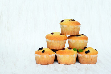 Freshly baked homemade muffins - vanilla muffins with raisins, decorated with melissa leaves