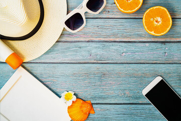 Beautiful summer holiday, Beach accessories, orange, sunglasses, hat, sunblockand smartphone on wooden backgrounds