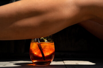 Glass of aperol spritz ad woman legs