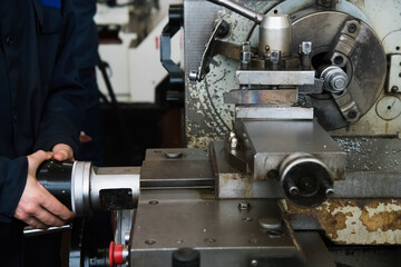 Heavy industrial worker performs a mechanical operation on a machine for the production of steel structures