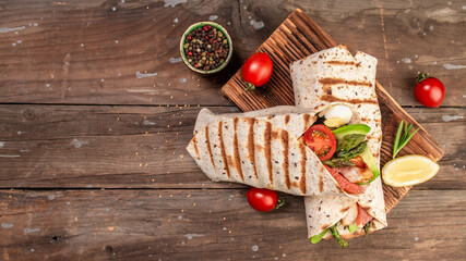 Tortilla wrap with asparagus, cherry tomatoes, avocado, chicken fillet and fresh salad. healthy food. Top view. banner, menu recipe place for text