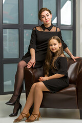 Mom and little daughter, in the studio, near a large panoramic window.