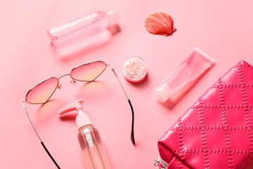 Beach accessories with sunscreen cream on color background