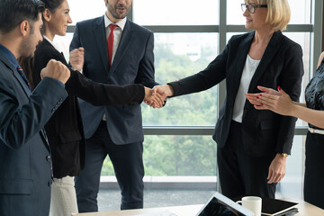 Business people handshake in corporate office showing professional agreement on a financial deal...