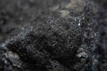 Blurred black background in soft focus with hard coal at high magnification