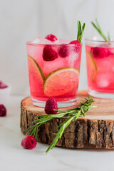 Cold  fresh summer berry lemonade with rosemary,raspberry and ice in glass 