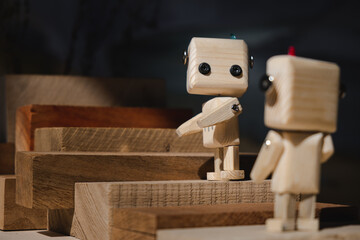 two small wooden robots climb up a ladder of wooden blocks. teamwork concept