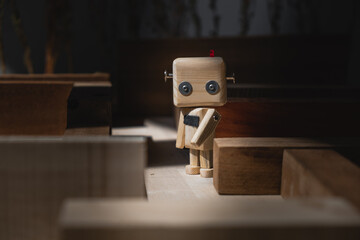 small wooden robot in a maze of wooden blocks. confusion concept