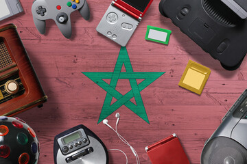 Morocco retro gaming concept. A collection of retro video game controllers shot from above on a national background. © sezerozger
