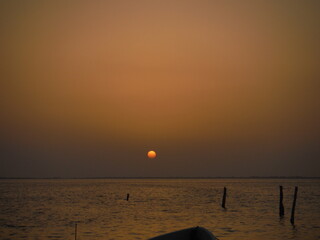 Sunset in the beach with the sun in the background and sea