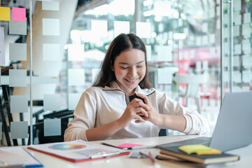 Charming asian businesswoman sitting working on laptop in office.