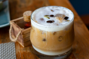Glass of ice coffee. Cold Coffee On a wooden Table. Selective focus, Summer drink iced coffee in glass and coffee beans on a table.