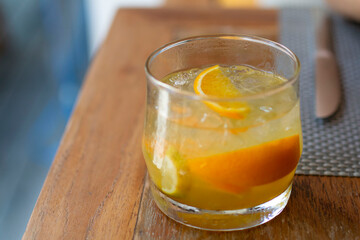 Cocktail with orange slices and ice cubes. Fruit Vodka. Orange cocktail decorated with lime and orange slice and ice.