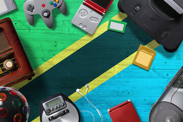 Tanzania retro gaming concept. A collection of retro video game controllers shot from above on a national background. © sezerozger