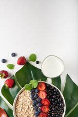 Healthy breakfast, muesli with currants, blueberries and strawberries served in bawl on light backgrund