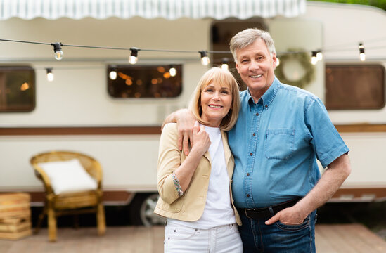 Portrait of mature couple embracing near their motorhome at campground, copy space
