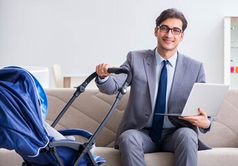 Businessman looking after newborn baby at home and teleworking