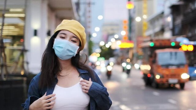 Asian woman standing outdoor wearing protective mask, covid-19 world pandemic, healthy lifestyle, new normal social distance,asian woman wear medical mask