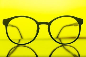glasses with transparent lenses with diopters on a yellow background. stylish accessory