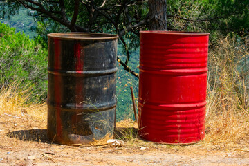 two steel barrels on the side of a road