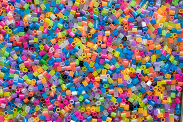 Fototapeta na wymiar multi-colored plastic beads, small pieces of plastic mosaic, background for children's creativity