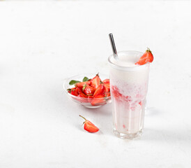 Milk cocktail with vanilla ice cream and strawberry juice in a glass on a white background copy space