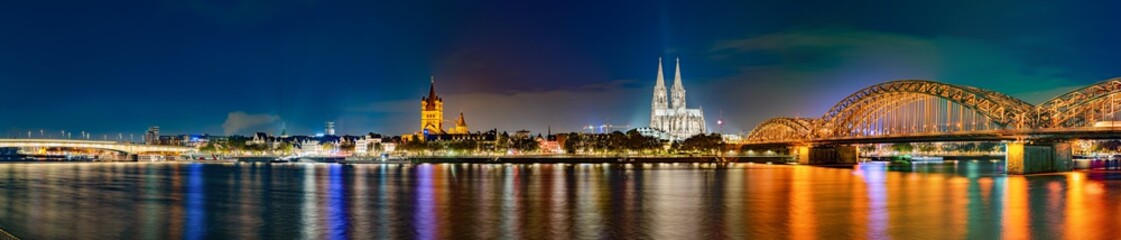 Panorama of Cologne by night, with Hohenzollern Bridge over the Rhine River and Cologne Cathedral