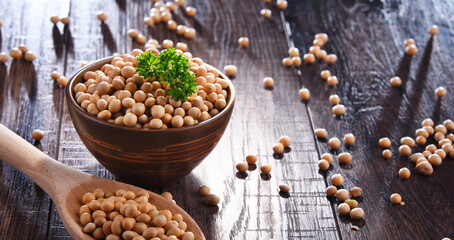 Composition with bowl of soya beans on wooden table