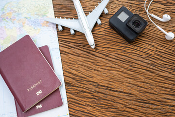 Passport with a map on old wooden background.Travel planning.Top view of traveler accessories with a camera, plane on world map.Preparation for travel.Traveling Journey Vacation Holiday concept.