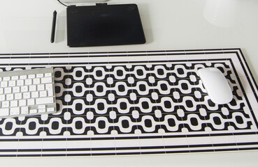 teclado y mouse encima de alfombra de mesa, tableta grafica, trabajo desde casa