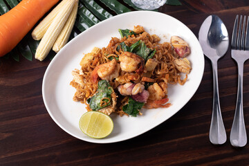 Stir fried instant noodles, stir-fry soy sauce, seafood on the wood floor