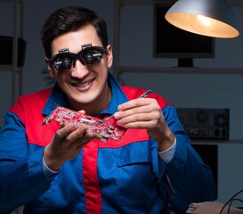 Computer specialist repairing PC late at night