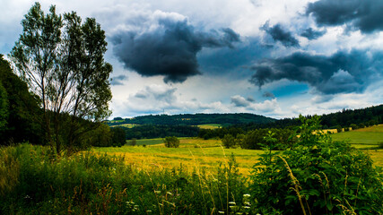 Rainy clouds over a mountainous field