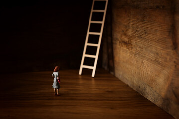 business concept picture of challenge. A woman stands infront of a a ladder. Problem solving and decision making.