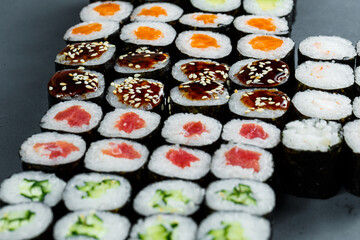 Japanese food. Rolls with ripe avocado, red fish, salmon, fresh rice with vegetables in nori. Set with rolls