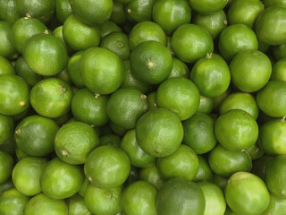 Fresh organic limes at a farm market stand displayed for sale 