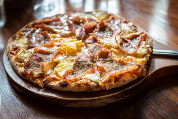 pizza with ham and mushrooms on a wooden board